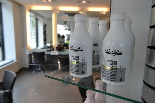 Flacons de soin posés sur une étagère en verre, face au salon