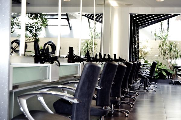 Postes de coiffage alignés devant les miroirs du salon d’Ixelles