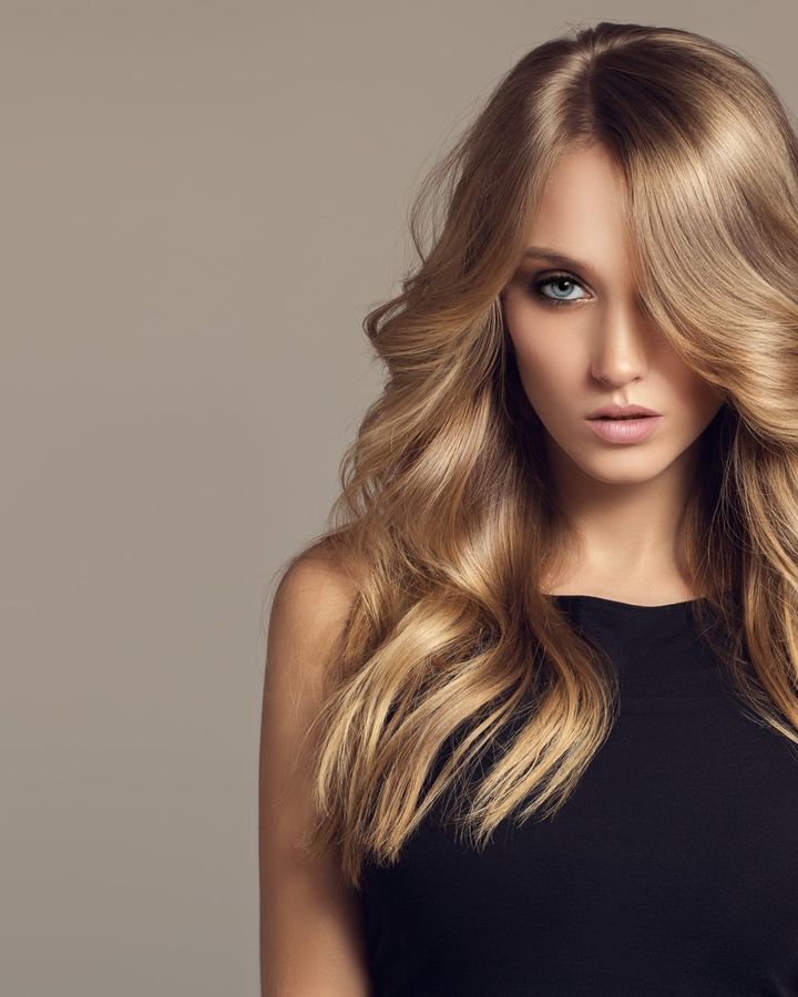 Longs cheveux blonds ondulés, éclaircis par un balayage