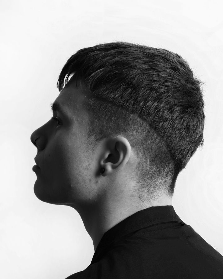 Profil en noir et blanc d’un jeune homme à la coupe courte dégradée